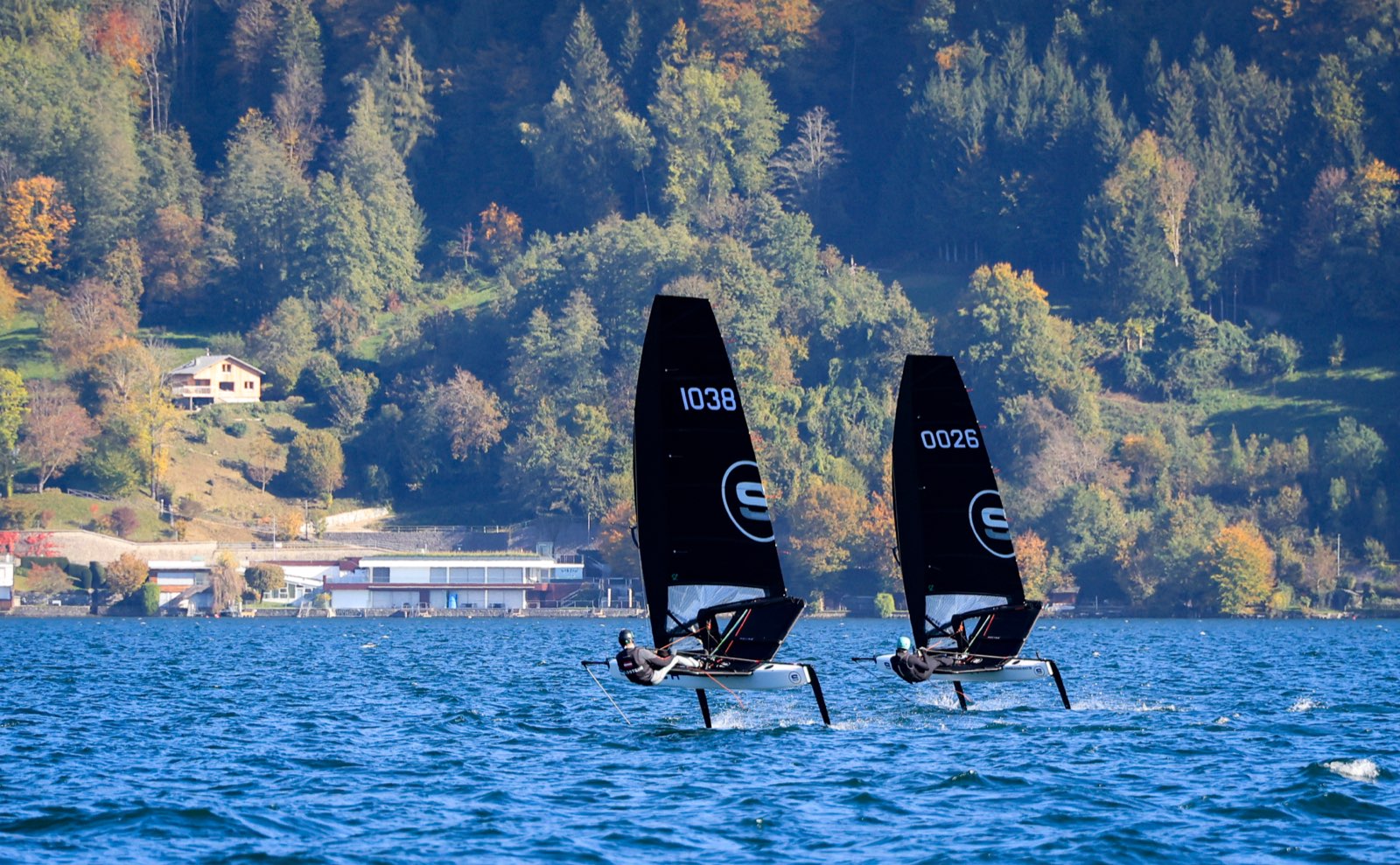 Zwei foilende Switch-Jollen vor dem Segelclub Kammersee