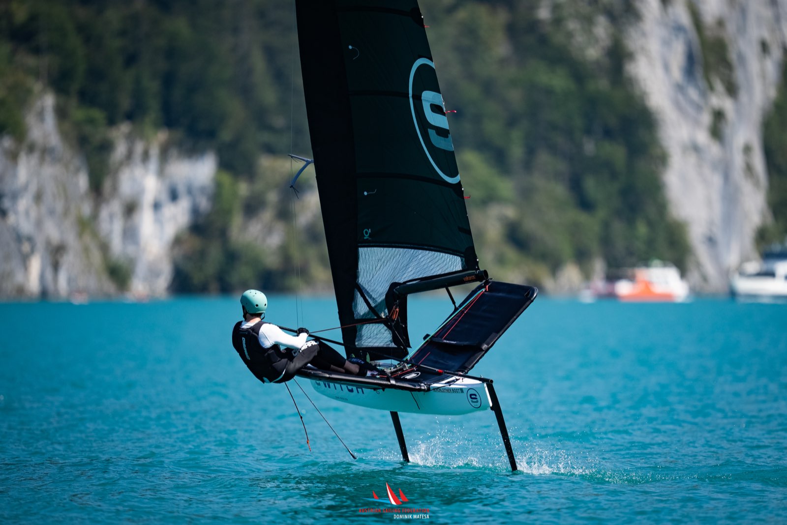 Switch-Segler foilt vor Felswand am See